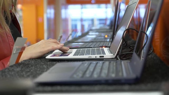 woman selects a laptop in an electronics store. 4k, slow motion