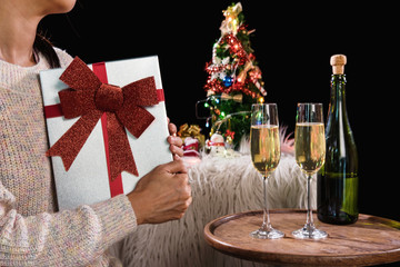 Beautiful women holding gift boxes and two glasses with champagne celebrating Christmas at corporate party, New Year Frame for your text