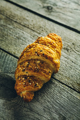 Crispy buttery croissants on old wooden table