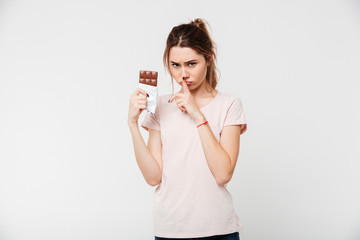 Portrait of a cute pretty girl holding chocolate bar