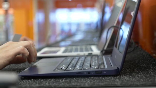 woman selects a laptop in an electronics store. 4k, slow motion