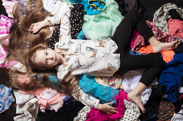 The girl is lying on the clothes