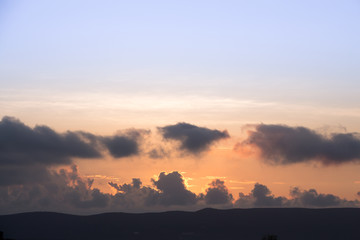Colorful dawn/dusk sky with dark clouds background.