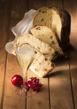Glass with champagne and Christmas cake on the wooden table