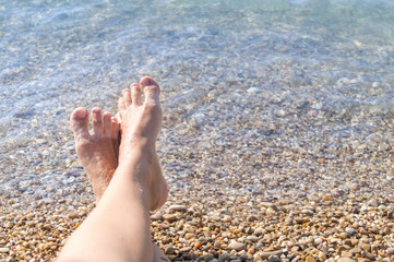 Female feet on the sea beach. Vacation concept. Space for text