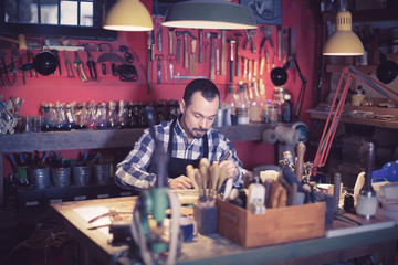 Naklejka premium Neat guy worker working on belt leather