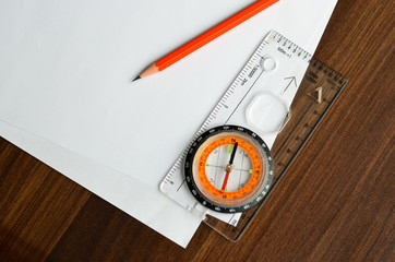 compass pencil white papers on wood sheet close up