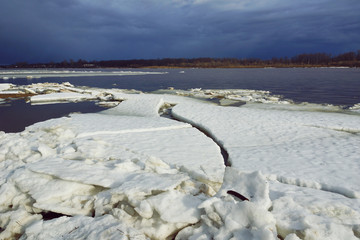 ice drift on the river huge ice floes white dark blue sky