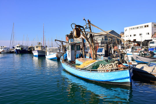 Old colorful fisherman boat tied to a pier in port of old jaffa in Israel.