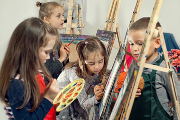 Children paint paint on canvas