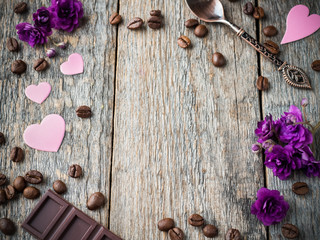 Decorations for Valentines day paper hearts, violets and chocolate coffee on rustic wooden background