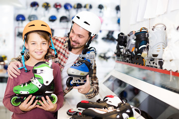 father and son deciding on new roller-skates in sports store
