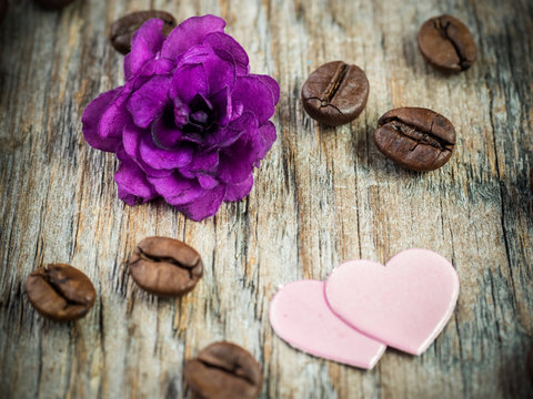 Decorations for Valentines day paper hearts, violets and chocolate coffee on rustic wooden background