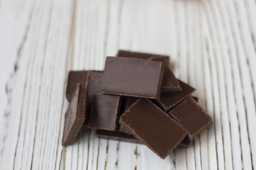 broken pieces of chocolate on white wooden table