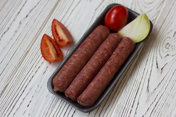 sausages and vegetables on white wooden table