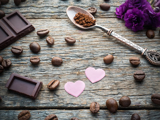 Decorations for Valentines day paper hearts, violets and chocolate coffee on rustic wooden background