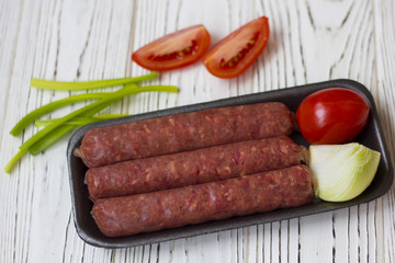 sausages and vegetables on white wooden table