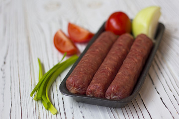 sausages and vegetables on white wooden table