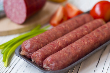 sausages and vegetables on white wooden table