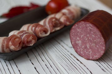 sausages, bacon, vegetables on white wooden table