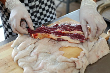 The chef prepares the meat and the skin of sheep's fat to cook roll.Uzbek cuisine.