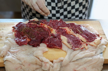 Obraz premium The chef prepares the meat and the skin of sheep's fat to cook roll,salt,spices.Uzbek cuisine.