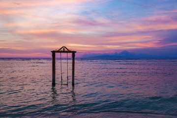 GILI TRAWANGAN, INDONESIA - NOVEMBER 10, 2017:  Beautiful sunset over the sea and swing