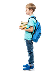 schoolboy with a bunch of books and a backpack on a white background in full length side view