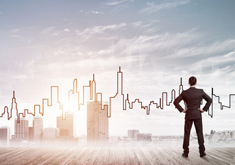 Motivation and inspiration concept with modern cityscape and businessman observing it