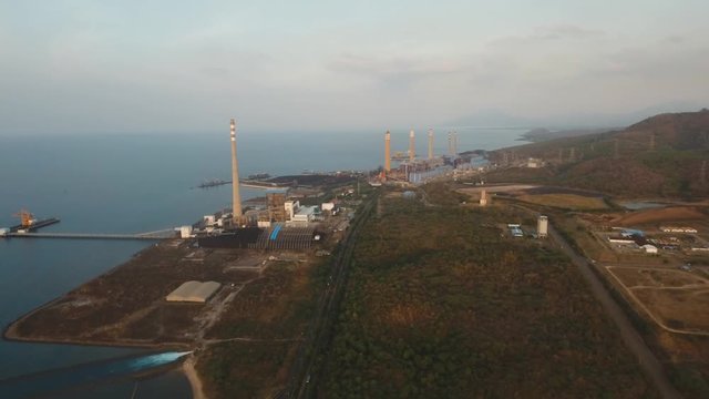 Aerial view Power station on the sea coast. Larger Industrial power plant in Indonesia. Power Plant cables and wires. 4K, aerial footage.