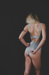  blond woman in blue lace lingerie holding her fit butt