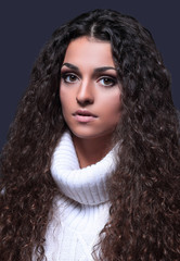 Portrait of a beautiful woman with curly hair in a sweater