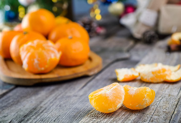 Christmas concept with Tangerines, Fir branches with decor , gifts and spices on the old rustic wooden table. New year background. Selective focus. Vintage toning. Space for text.