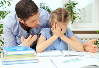 Dad is angry because his daughter don't want to do her homework.