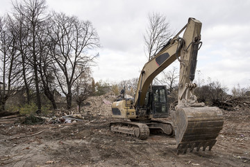 huge yellow shovel digger on demolition site