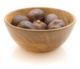 Snake fruit in a wooden bowl isolated on white background.