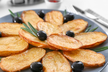 Delicious baked potatoes with rosemary on plate, closeup