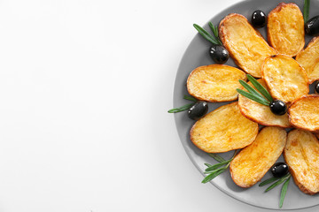 Plate with delicious baked rosemary potatoes on white background
