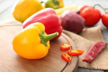 Board with peppers on table, closeup