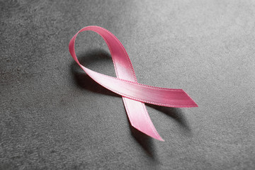 Pink ribbon on gray table. Breast cancer concept