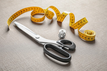 Measuring tape, bobbins and scissors for tailoring on fabric
