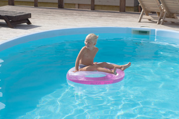 Blonde kid having good time in pool, little girl swimm in sumertimes 
