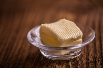 close up butter in a dish  on old wood background