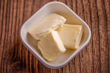 close up butter in a dish  on old wood background