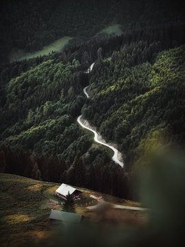 Einsame Almh&uuml;tte in den Bergen mit Weg umgeben von Wald