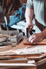The carpenter in the workshop makes frames for paintings.