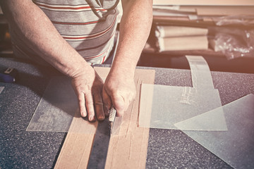 The carpenter in the workshop makes frames for paintings.