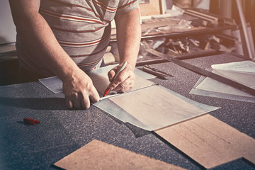 The carpenter in the workshop makes frames for paintings.