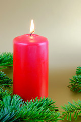 Christmas composition with red candle and fir branches.