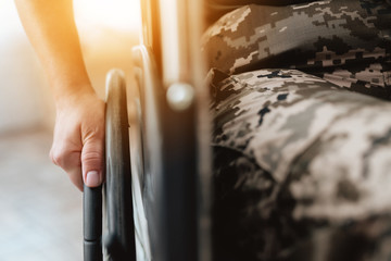 Woman veteran in wheelchair returned from army. Close-up photo veteran woman in a wheelchair. - obrazy, fototapety, plakaty